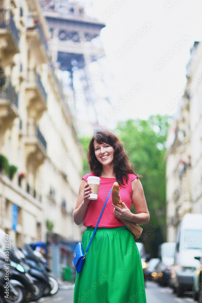 French woman walking with coffee to go and baguette on a street of Paris French woman walking with coffee to go and baguette on a street of Paris