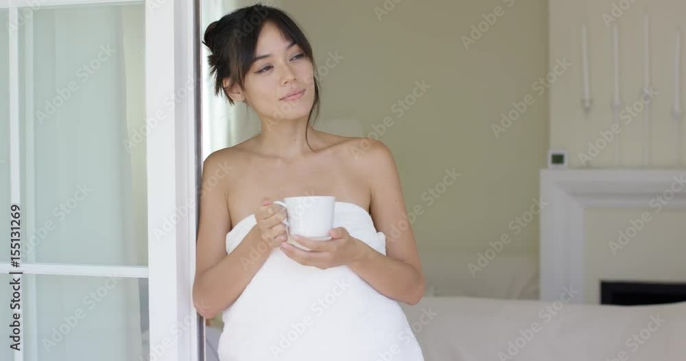 Man kissing pretty woman in white towel at doorway for hotel resort bedroom facing outside Man kissing pretty woman in white towel at doorway for hotel resort bedroom facing outside