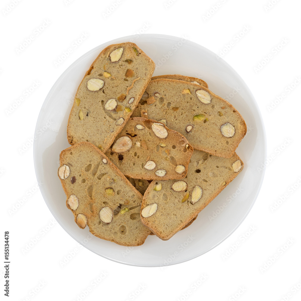 Top view of almond pistachio crisp bread slices on a plate isolated on a white background. Top view of almond pistachio crisp bread slices on a plate isolated on a white background.