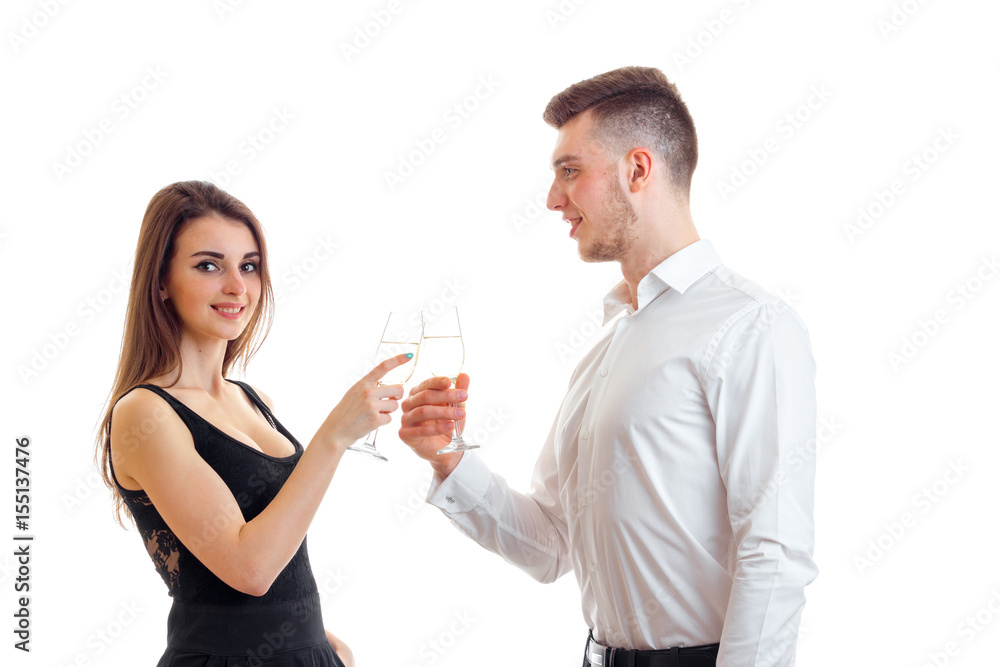 beautiful romantic couple standing beside smiling and carrying white wine glasses beautiful romantic couple standing beside smiling and carrying white wine glasses