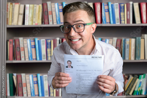 Funny guy (student, businessman)  looking for a job and holding his resume