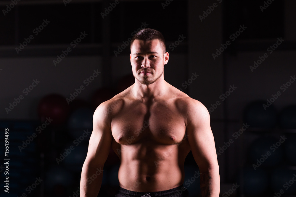 Young handsome muscular man bodybuilder posing