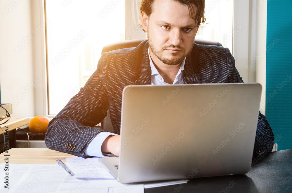 Businessman working laptop in modern loft office at sunset Businessman working laptop in modern loft office at sunset