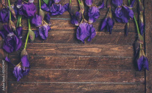 Fototapeta Naklejka Na Ścianę i Meble -  Purple iris flowers on wooden background. Retro styled floral texture.