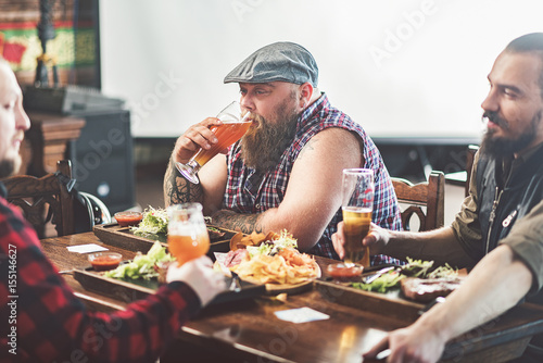 Three men drinking lager in pub