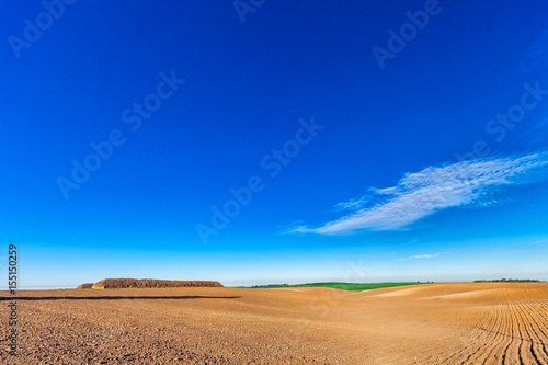 plowed field and cloudy sky in sunset