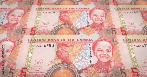 Banknotes of five gambian dalasis of Gambia rolling, cash money, loop photo