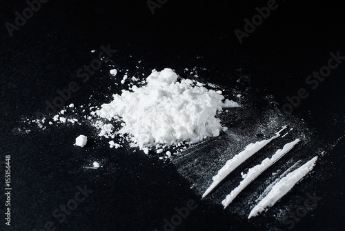 Heroin divided into paths on a black background photo