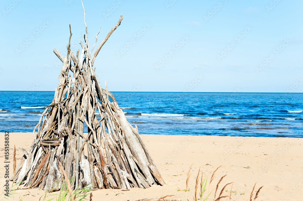 Fototapeta premium Wigwam Made from wooden branches on the sand of baltic sea beach