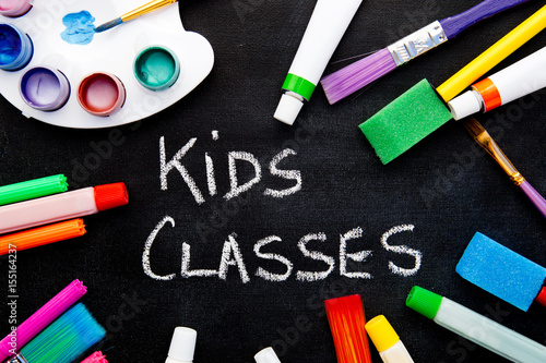 Art - Kids Classes - handwritten on chalkboard surrounded by art equipment
 photo