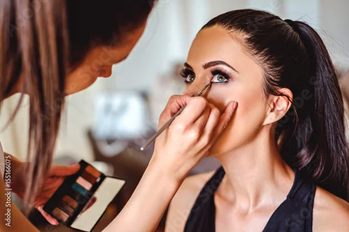 Obraz Makeup artist applying eyeshadow on a girl
