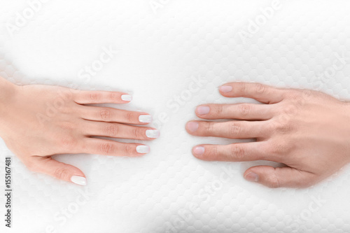 Male and female hands on orthopedic pillow. Healthy posture concept