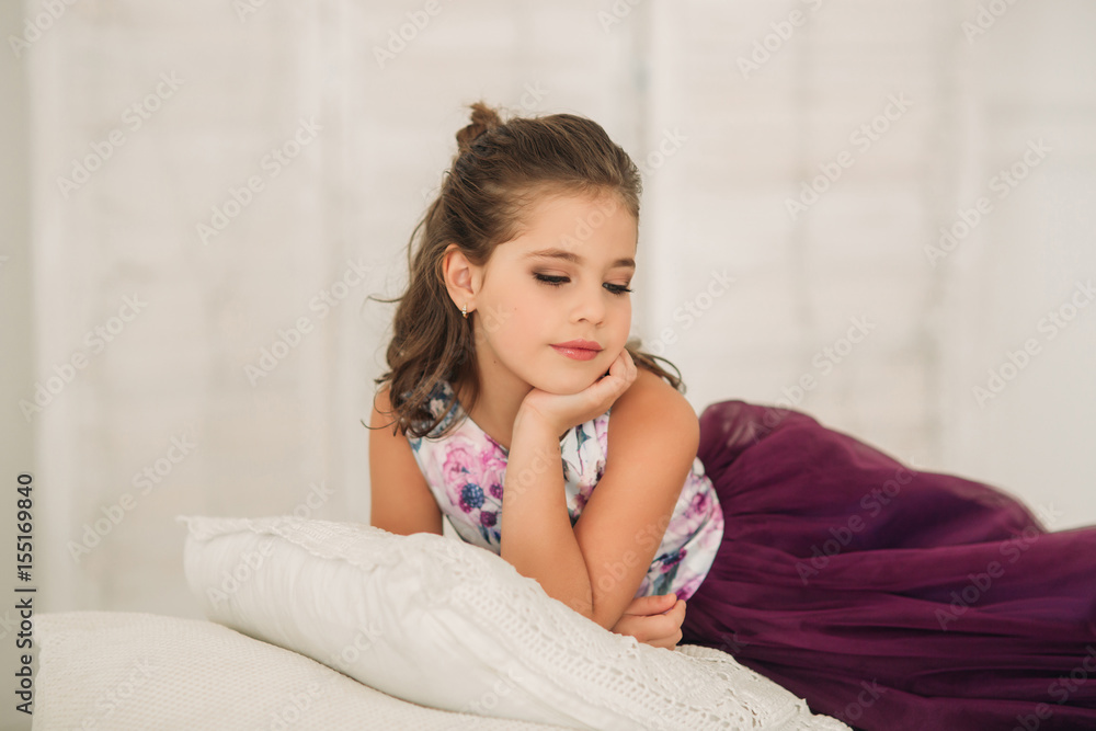 Beautiful girl in a purple dress and flower blouse posing for a photographer. Beautiful girl in a purple dress and flower blouse posing for a photographer.