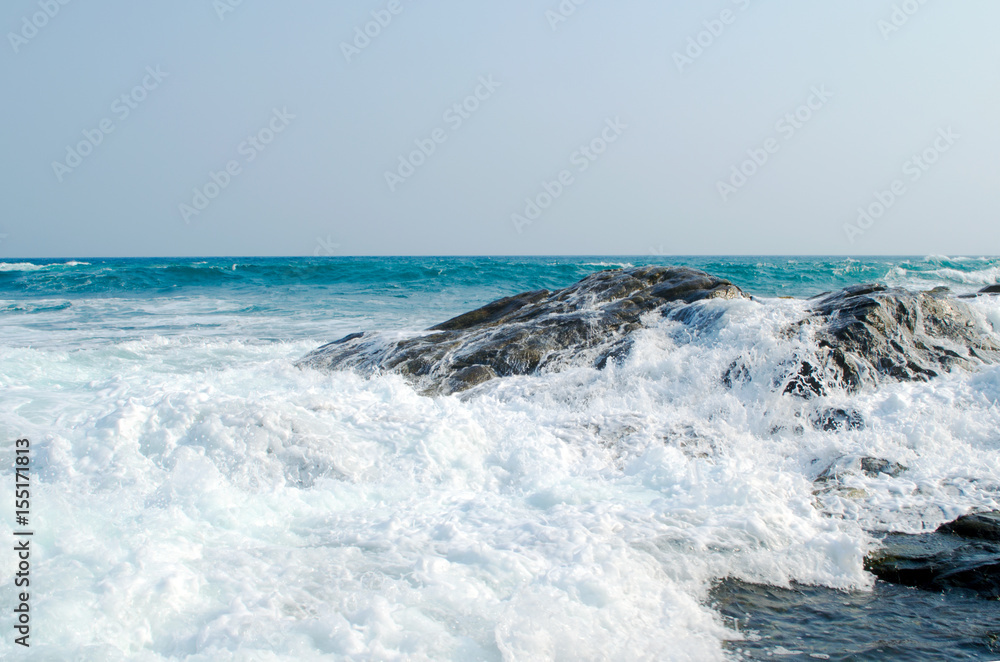 The sea wave is crashed about the shore and rocks