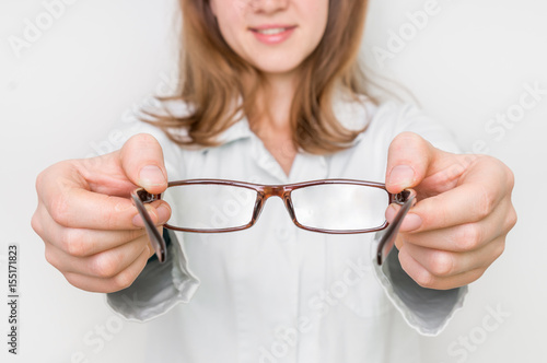 Female oculist doctor giving glasses to patient