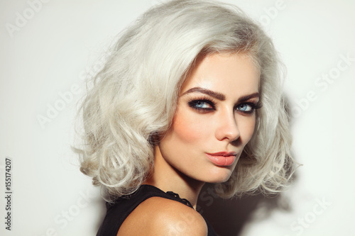 Vintage style portrait of young beautiful platinum blond woman with smoky eyes make-up