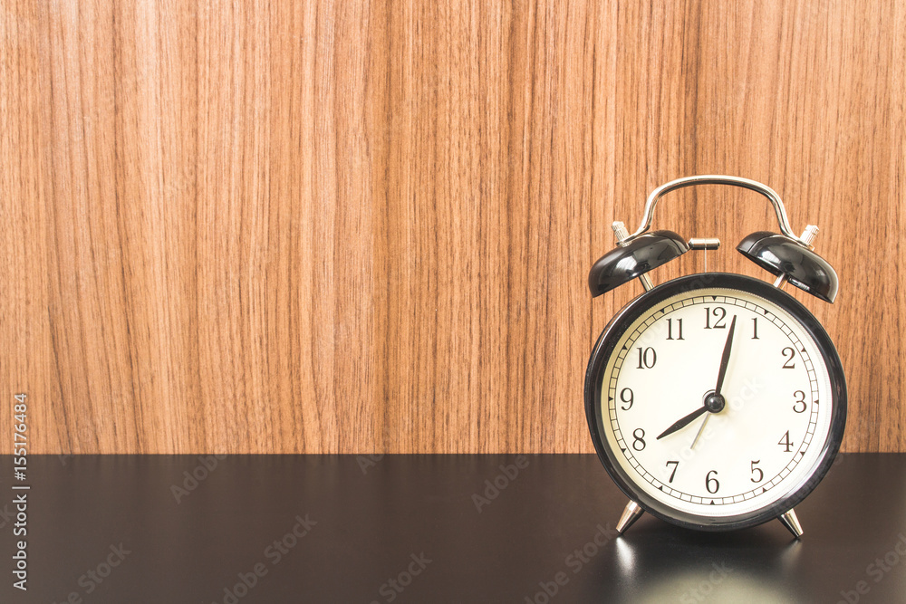 Wooden Background with Alarm clock on Black table. Wooden Background with Alarm clock on Black table.
