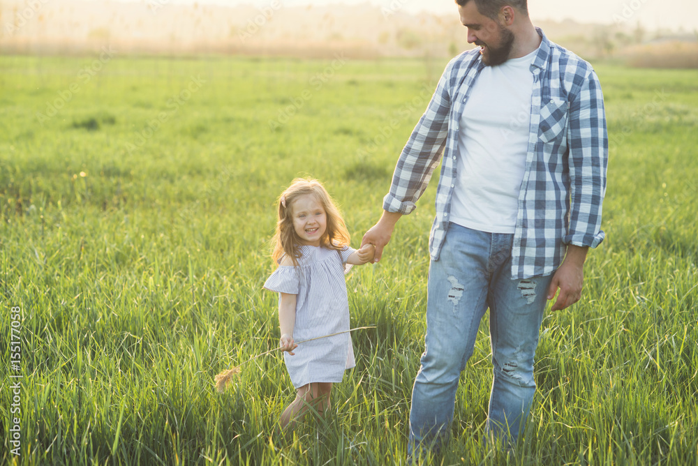 father and daughter walking in high grass field father and daughter walking in high grass field