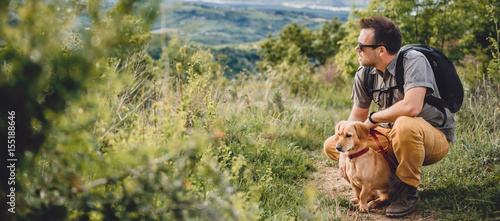 Man with a dog resting at the hiking trail