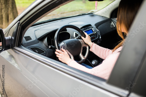 Confident and beautiful young woman in casual wear driving a car