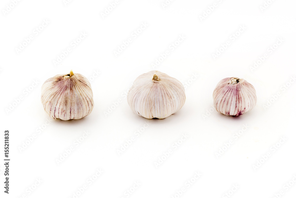Obraz premium Three fresh Young bulbs of garlic neatly isolated on white background