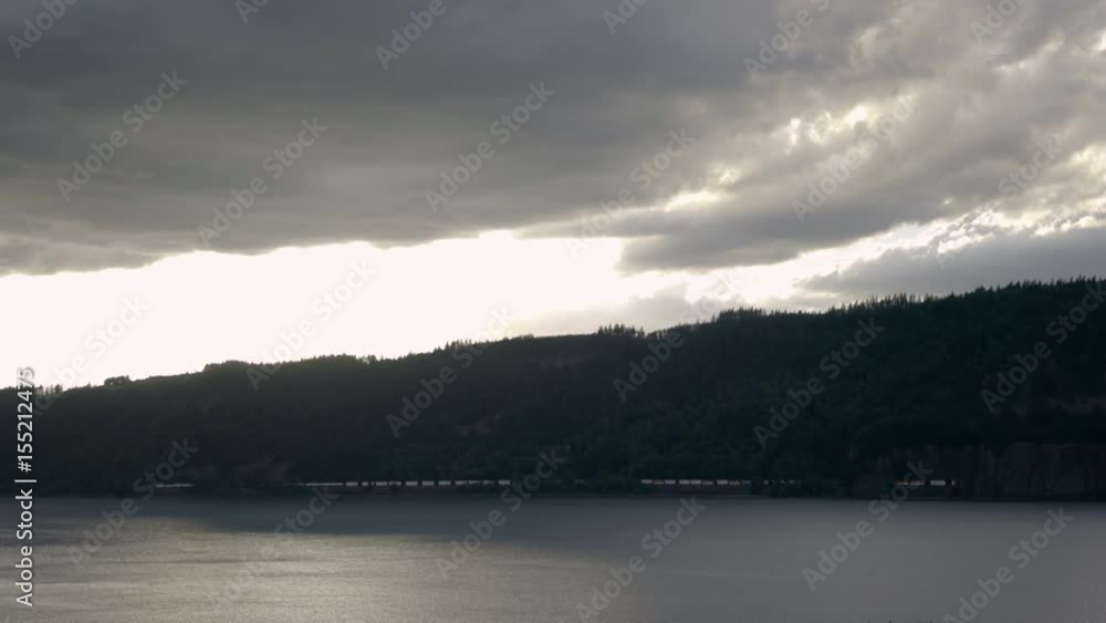 Static Shot Of Moody Clouds Over The Columbia River Gorge, Freight Train Passes By Across River Static Shot Of Moody Clouds Over The Columbia River Gorge, Freight Train Passes By Across River