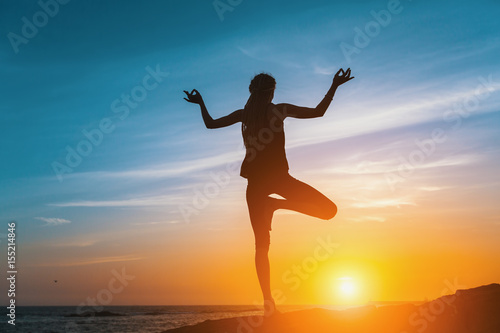 Yoga silhouette. Meditation girl on the sea during sunset. Fitness and healthy lifestyle.