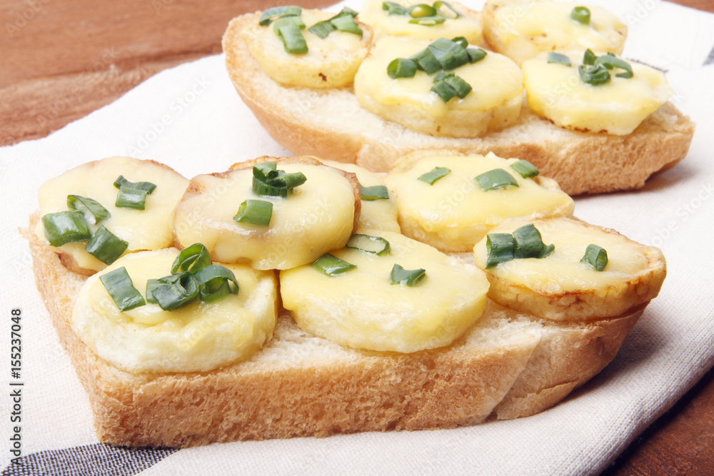 Appetizer of wheat bread, potatoes, cheese and green onions