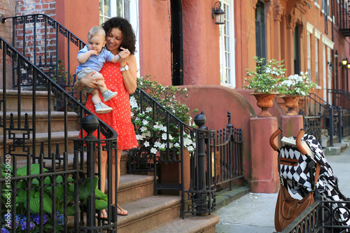 Mother with child in a stroller walking in the street