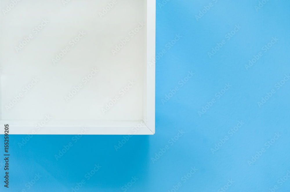 White box shelf isolated on blue background..Empty white shop shelf, retail shelf on blue vintage background.
