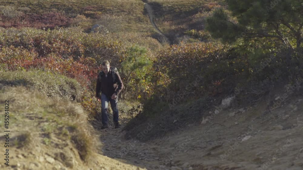 Excited Hiker Drops His Pack On Trail And Runs Uphill To The Top, He Raises His Arms In Triumph And Shouts With Joy Excited Hiker Drops His Pack On Trail And Runs Uphill To The Top, He Raises His Arms In Triumph And Shouts With Joy