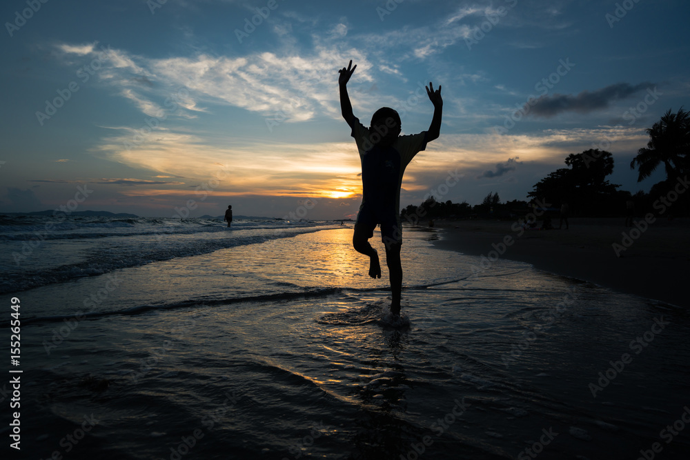 Silhouette of child jumping on the beach