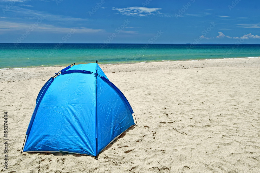 Fototapeta premium sun tent on white sand beach in front of turqouise water in a sunny day with white clound and blue sky.