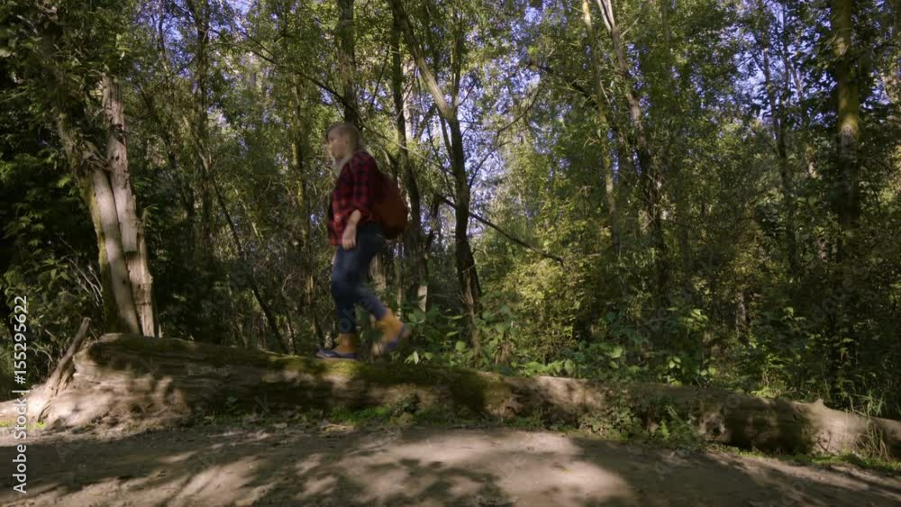 Young Woman Explores Forest, Balances On A Log, Looks Around At Beauty, Jumps Off Young Woman Explores Forest, Balances On A Log, Looks Around At Beauty, Jumps Off