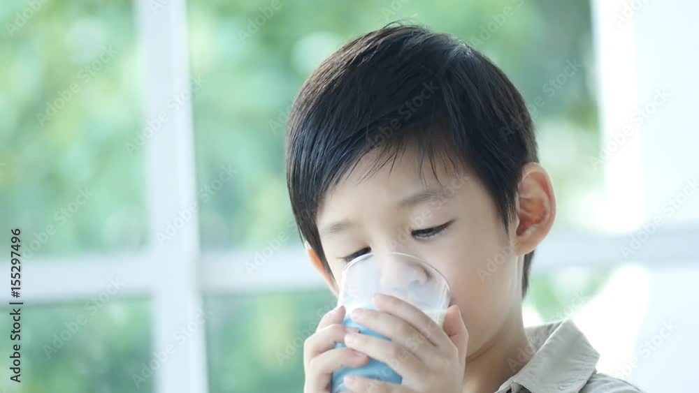Cute Asian child drinking milk from a glass Cute Asian child drinking milk from a glass