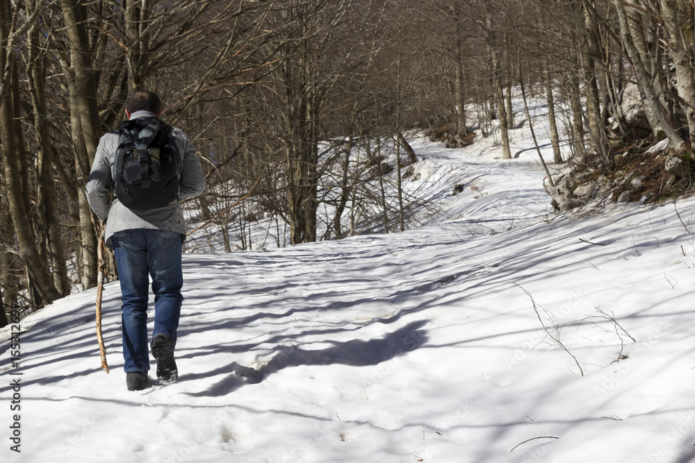 hiker on mountain trail with snow in matese park