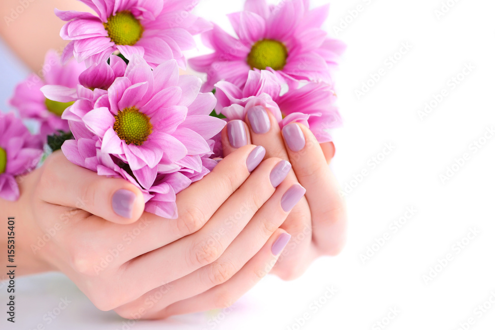 Hands of a woman with pink manicure on nails and pink flowers Hands of a woman with pink manicure on nails and pink flowers