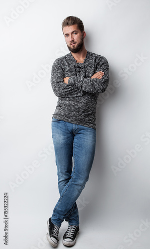 Portrait eines jungen hübschen Mannes an einer weißen Wand gelehnt © Cara-Foto