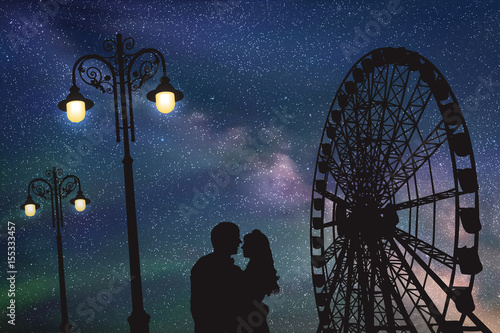 Lovers in amusement park at night. Vector illustration with silhouette of loving couple under starry sky. Vintage lampposts and Ferris wheel