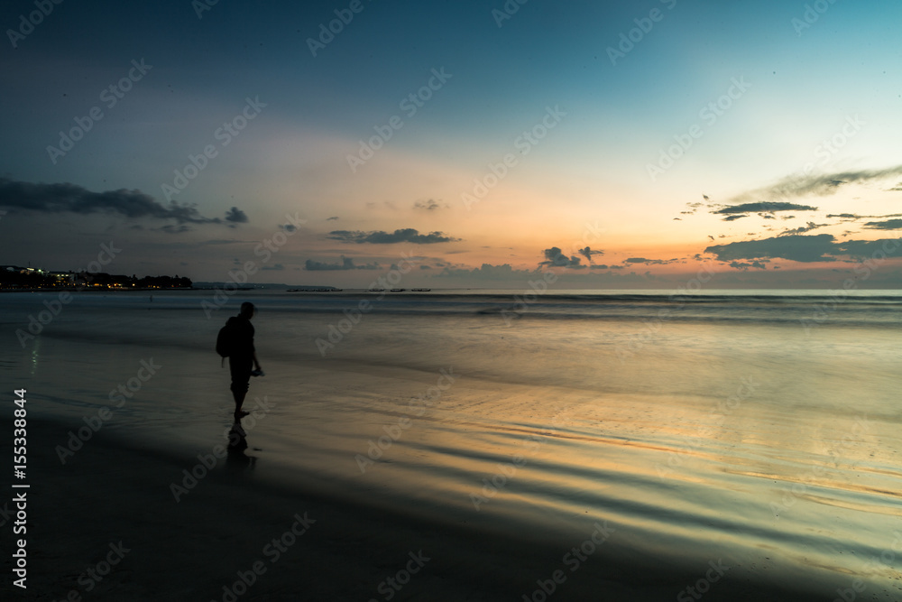 Beautiful sunset of Kuta Beach, Bali, Indonesia. Silhouettes of people at sunset on Kuta beach in Bali, Indonesia