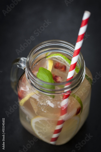 Lemonade in mason jar with fruit clices on a wooden table photo