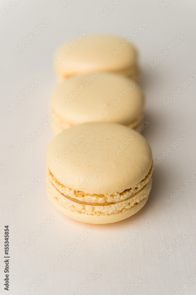 Sweet yellow macaroons on white table background. Sweet yellow macaroons on white table background.
