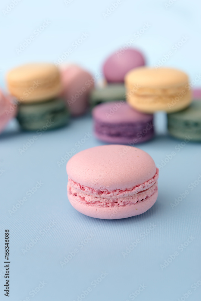 Sweet colorful macaroons on blue table background Sweet colorful macaroons on blue table background