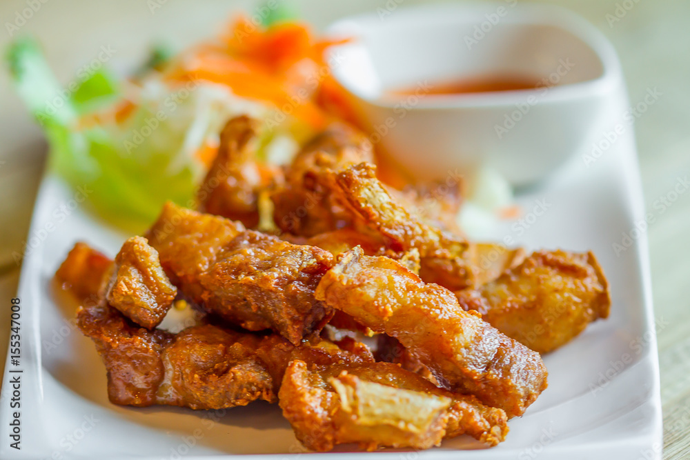 Sun dried pork fried on white dish with chilli sauce in restaurant Sun dried pork fried on white dish with chilli sauce in restaurant