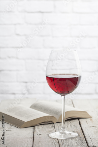 Wine glass and book in a white wooden table