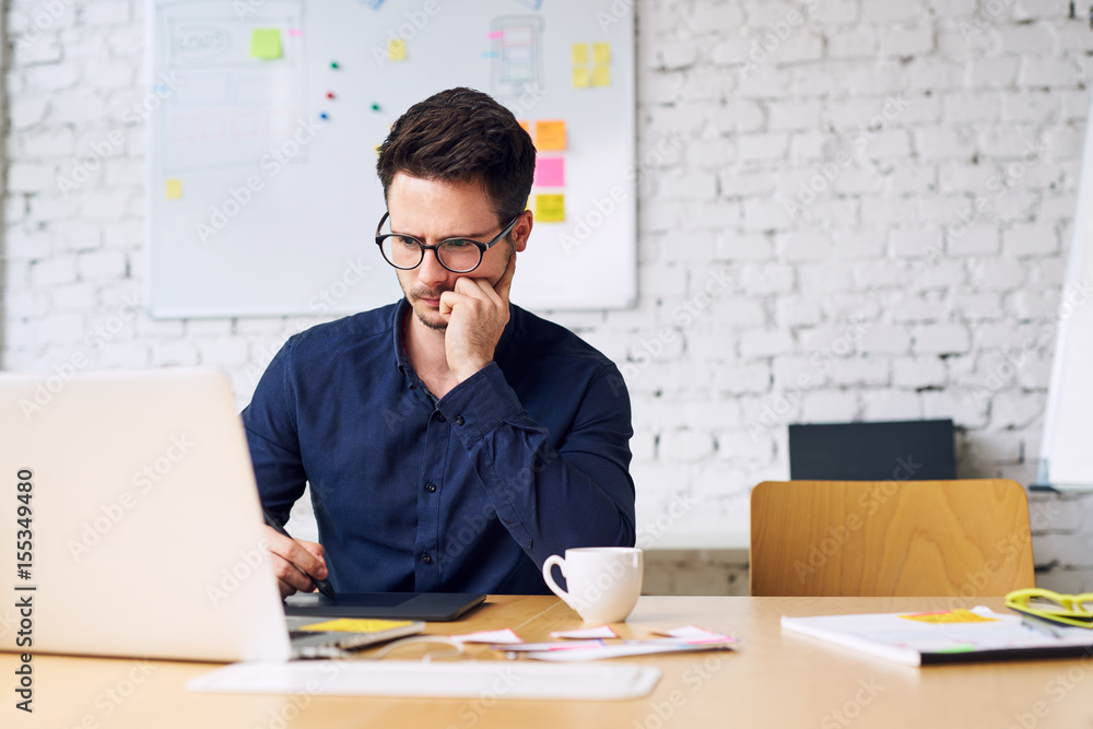 Fototapeta premium Thoughtful web designer, artist working at creative agency office
