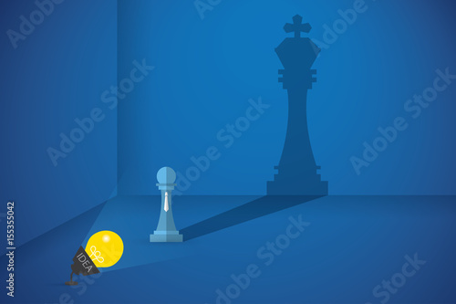 lightbulb flash the pawn chess to shows big shadow of king chess, idea and business concept