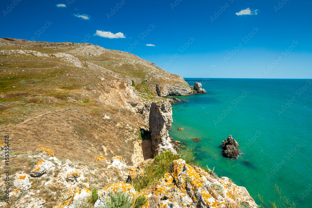 View of the open sea. Rocky seashore with blue sky. Beautiful nature