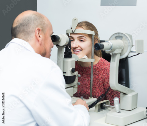 Ophthalmologist and woman checking eyesight