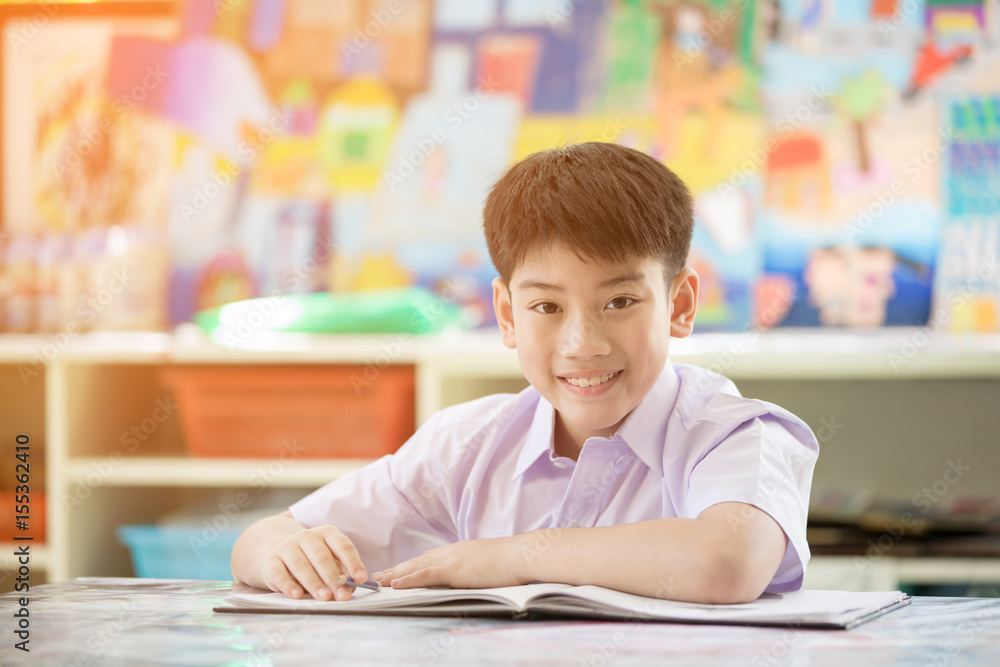 Happy asian child reading book and looking camera. Happy asian child reading book and looking camera.